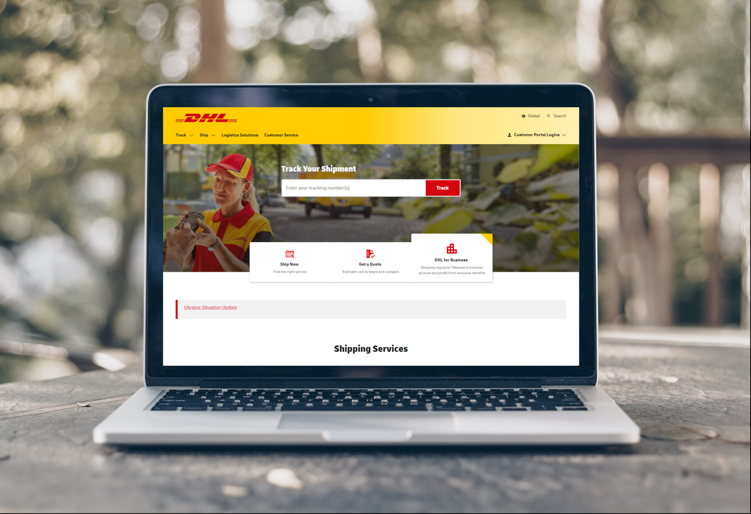 Laptop mit aufgerufener Seite der DHL, auf einem Balkontisch platziert