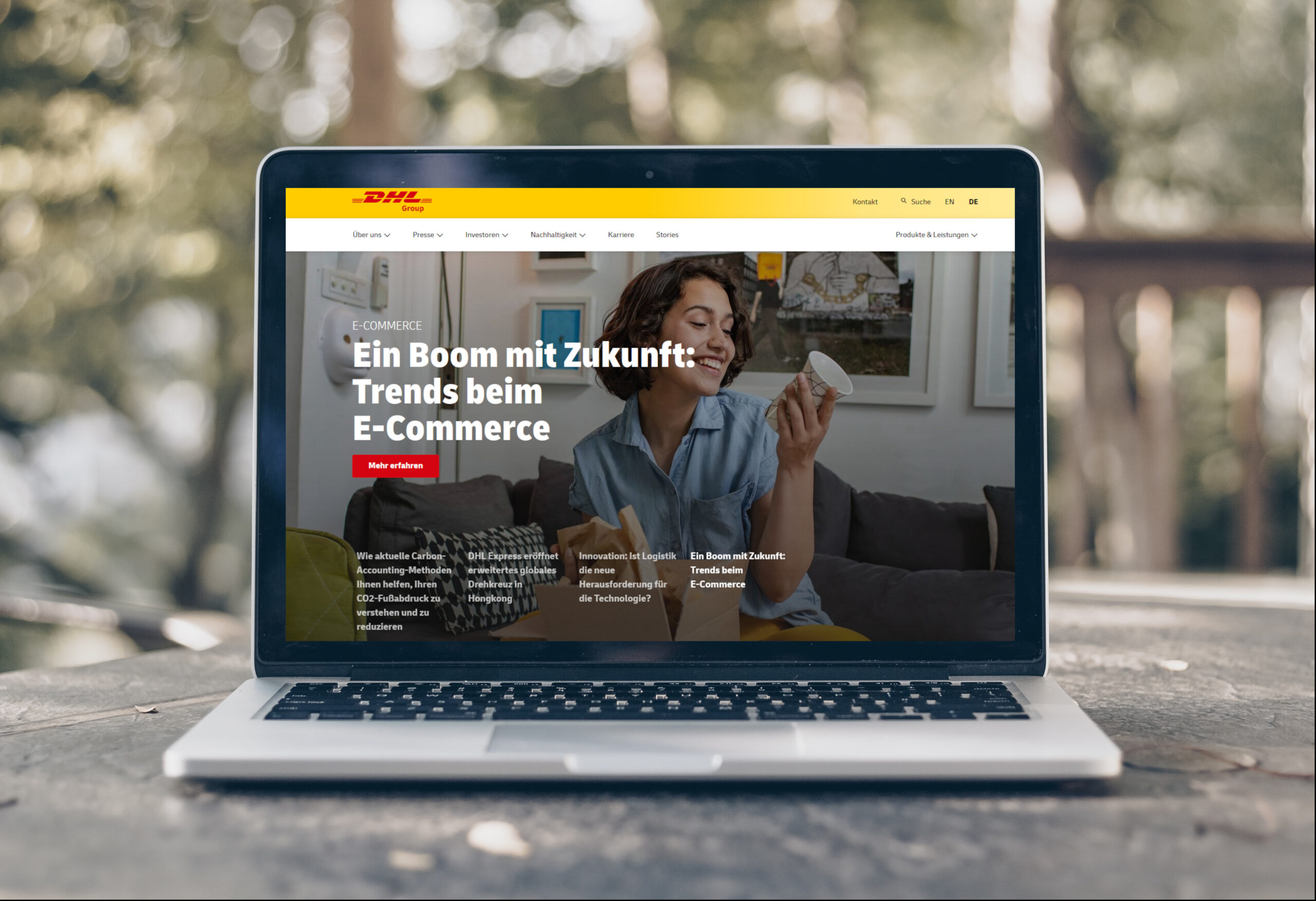 Laptop mit aufgerufener Seite der DHL Group, auf einem Balkontisch platziert