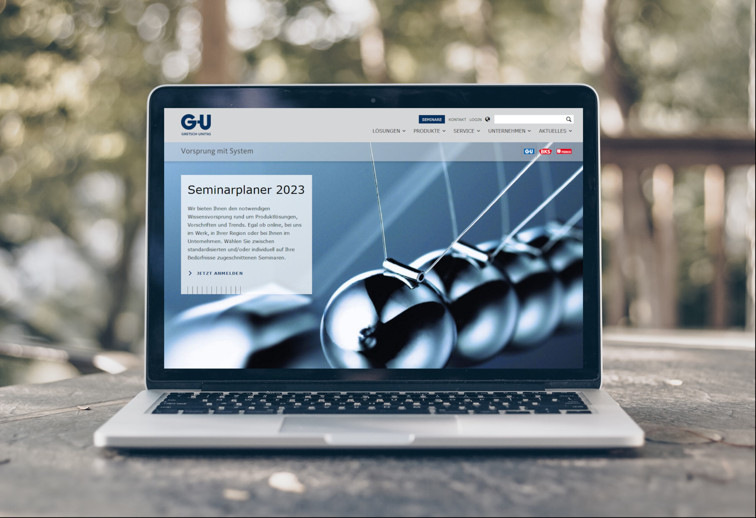 Laptop mit aufgerufener Seite der Firma Gretsch Unitas, auf einem Balkontisch platziert